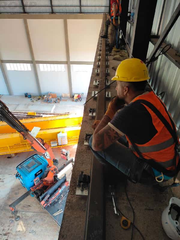 Workers are installing tracks on the steel structure